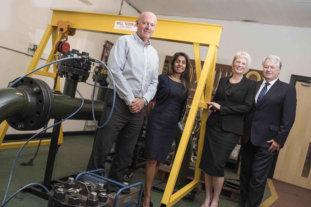 2 men and 2 women from Nordic Products and Services stood near engineering equipment