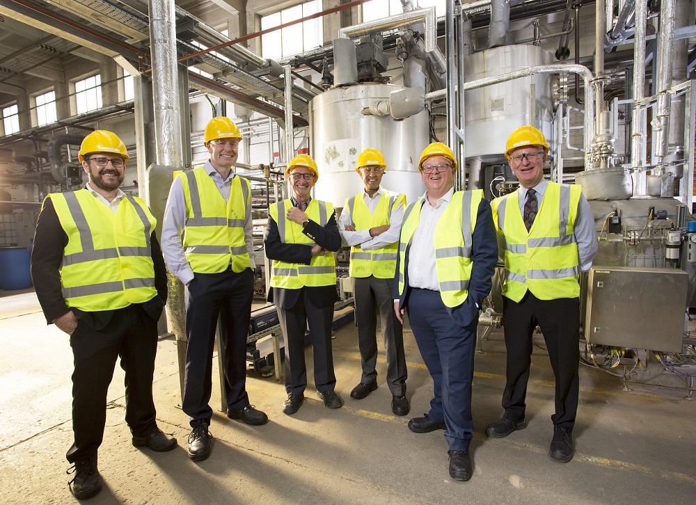 6 men in Hi Vis jackets and hard hats stood in a waste biomass factory