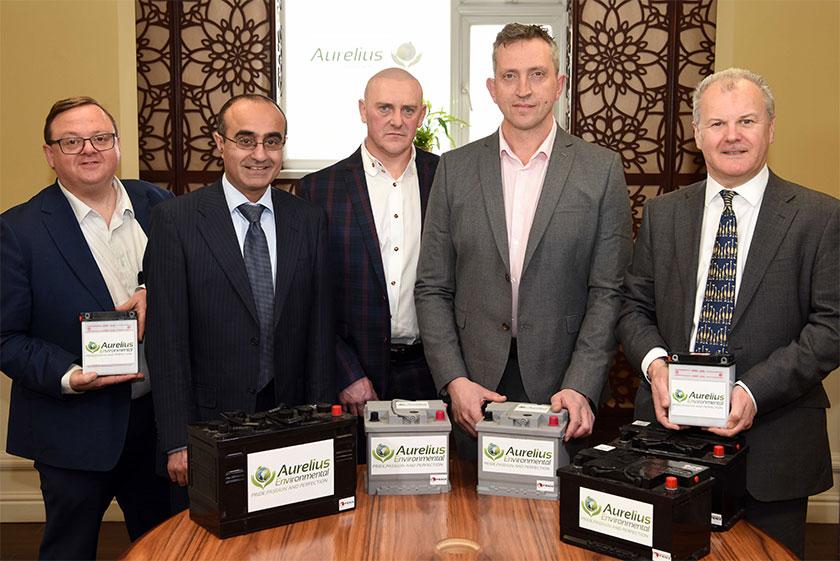 5 men in suits stood around a table showing the Aurelius products