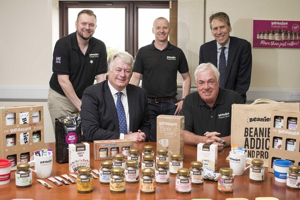 5 men gathered around a table of Beanies Flavour Coffee products