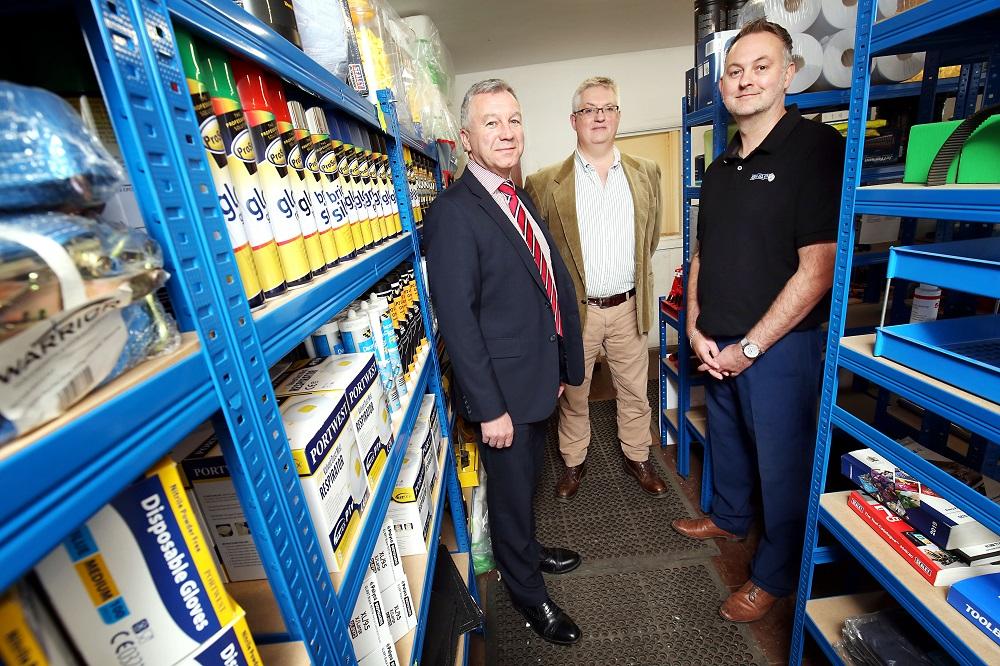 3 men stood in a warehouse of DIY products