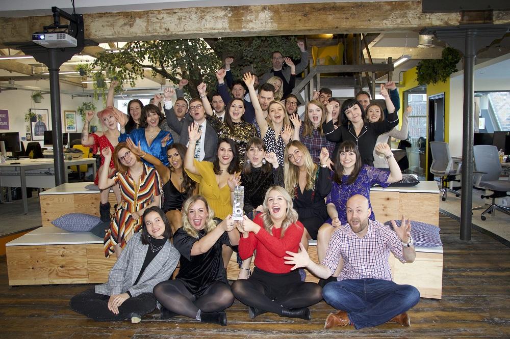 Employees from Buffalo 7 celebrating an award in an office