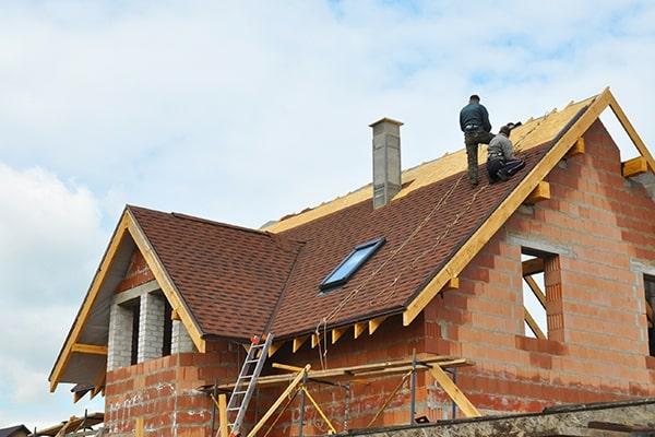 Builders working on constructing a roof on a new build home