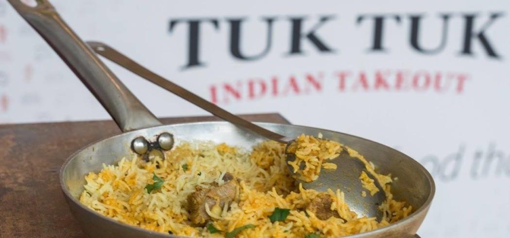 A rice dish in a frying pan with a Chilli Tuk Tuk sign in the background