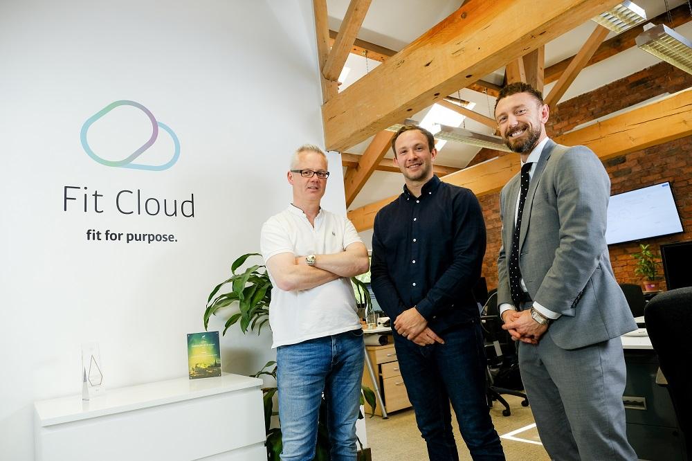 3 men standing in the Fit Cloud office with desks in the background