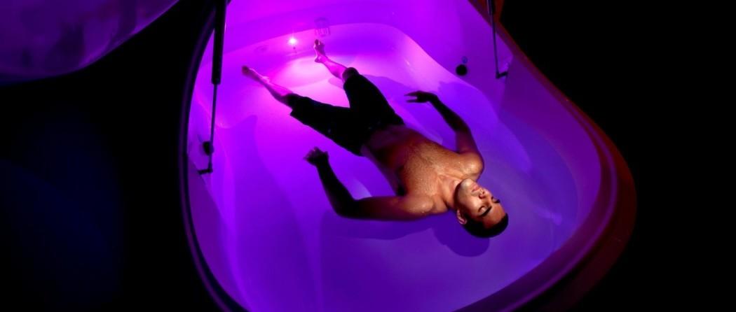 A man lying in a water flotation pod