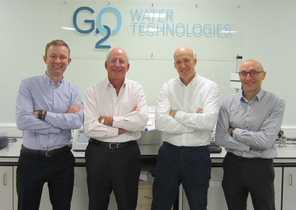 4 men stood with their arms crossed in an office with G20 Water Technologies logo on the wall behind them