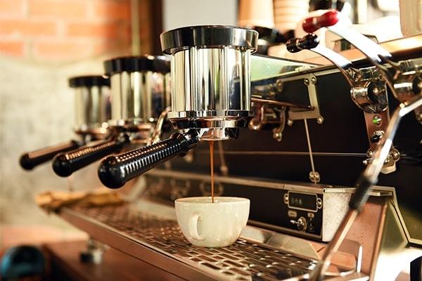 A coffee machine pouring coffee into a white mug