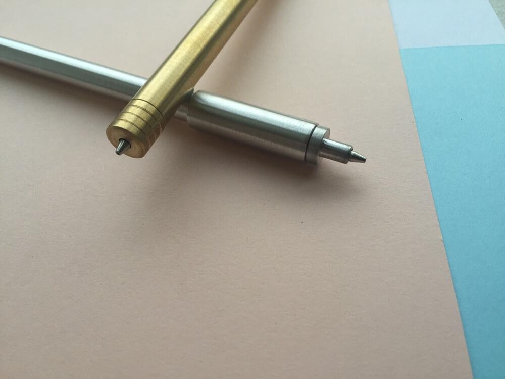 A gold and silver pen resting on top of a notebook