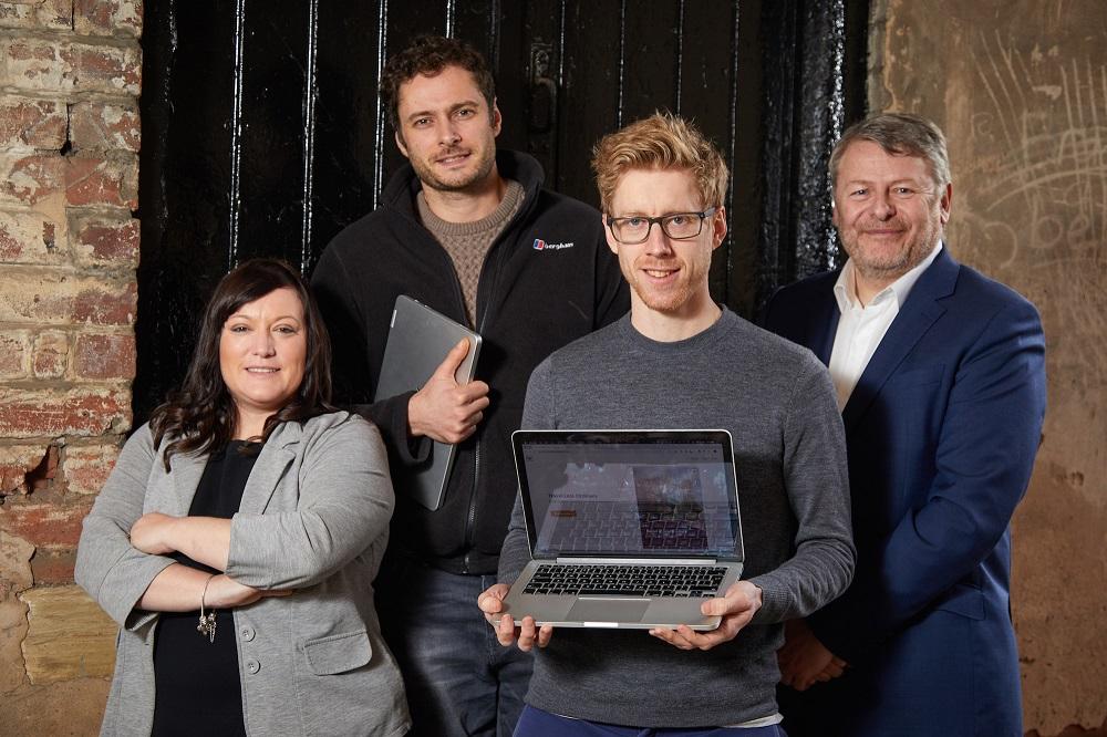 3 men and a woman from Horizon guides smiling with one man holding an open laptop and one man holding a closed laptop