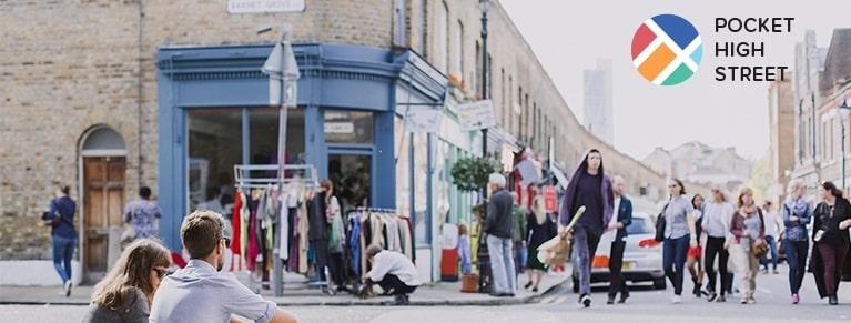 A lively street with shops, people and cars