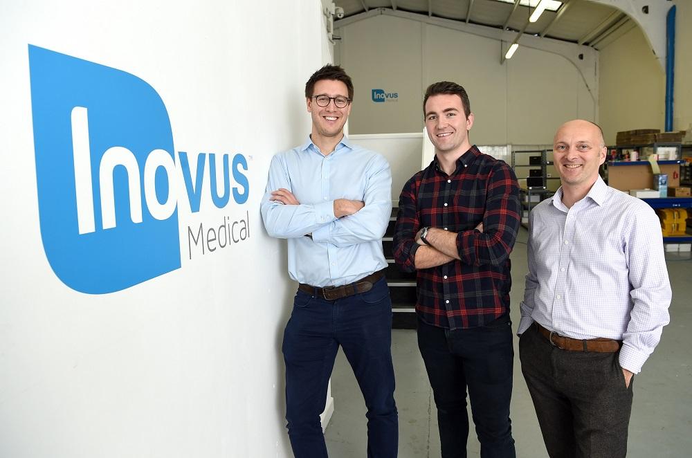 3 men stood near an Inovus Medical branded wall with office equipment in the background