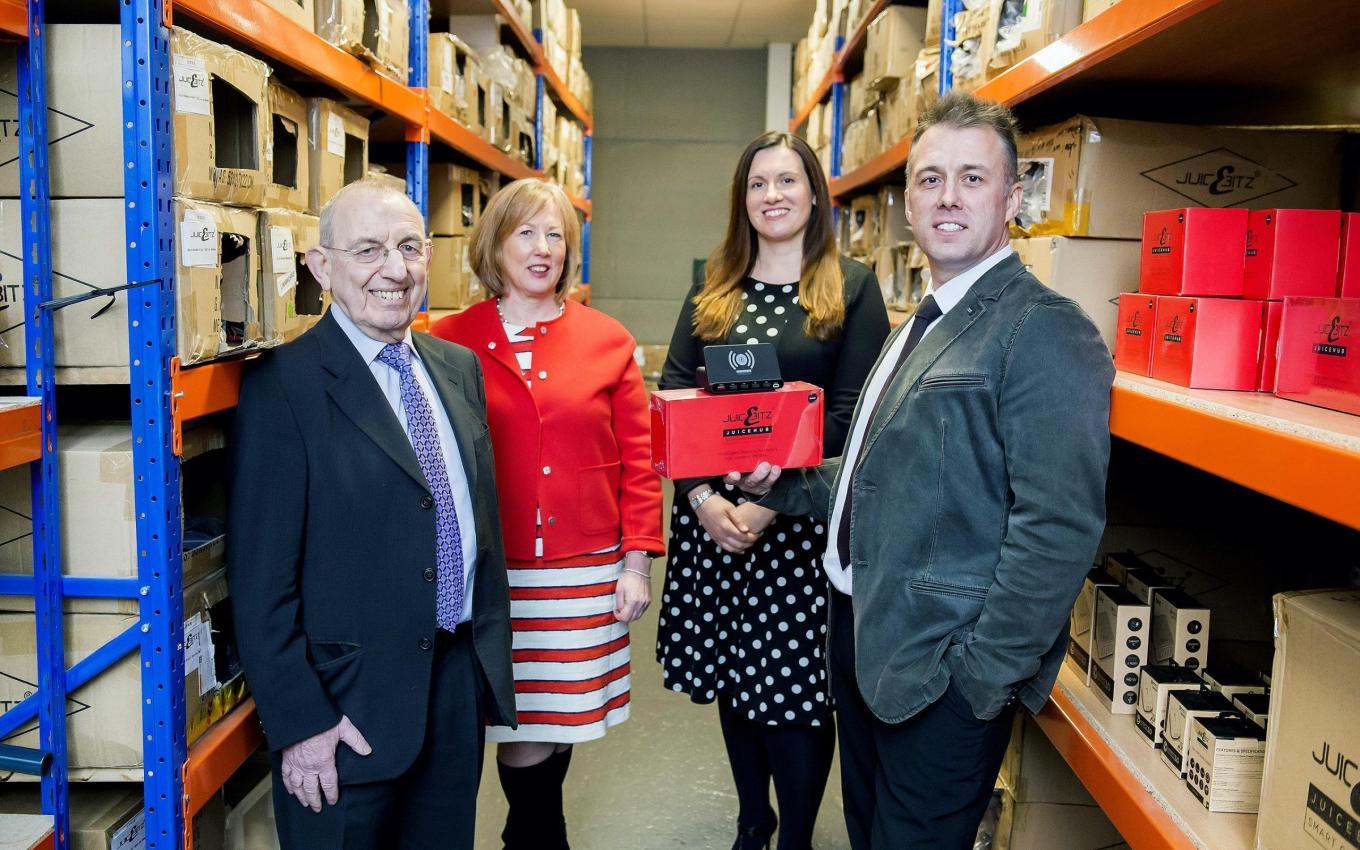 2 men and 2 women stood in a warehouse showing their audio device