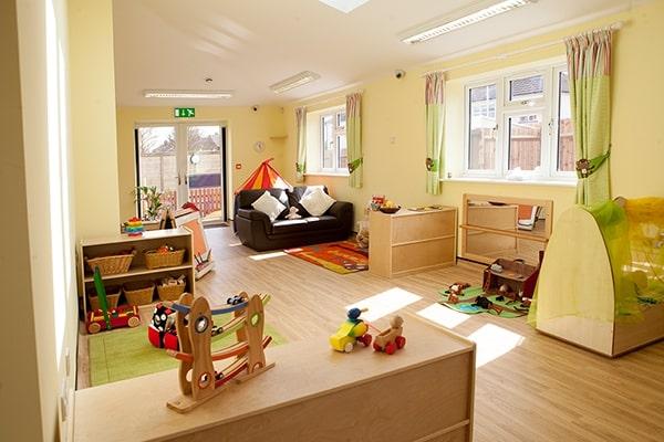 Baby room at Little Adventurers nursery, featuring furniture, wooden toys and little play areas