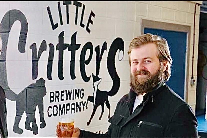 Matt Steer, MD of Little Critters Brewing Company, standing outside his brewery, holding a tankard of ale