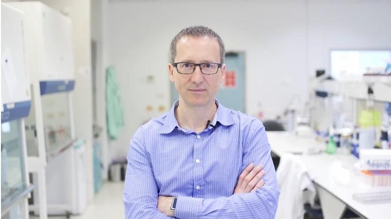 A man in a science lab stood with his arms crossed