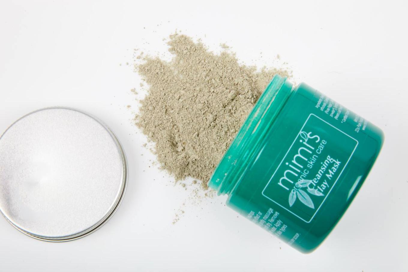 A pot of Mimi's Organics Cleansing Clay Mask spilling out on the counter