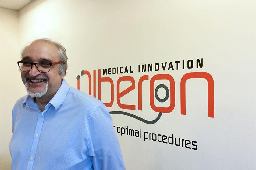 A man smiling and stood in front of an Olberon branded wall