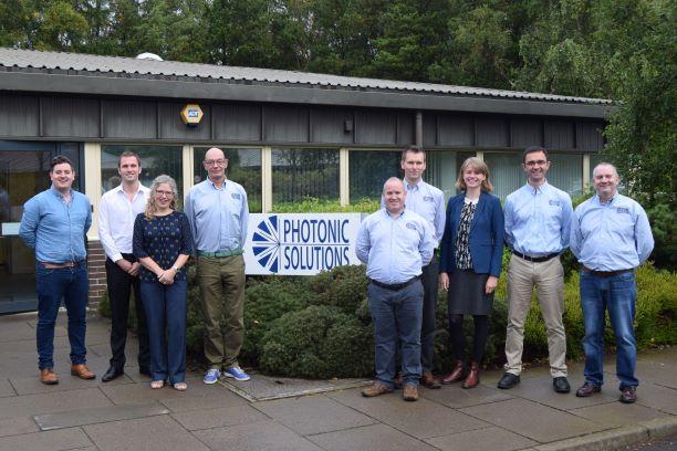 A group of employees stood in front of the Photonic Solutions office