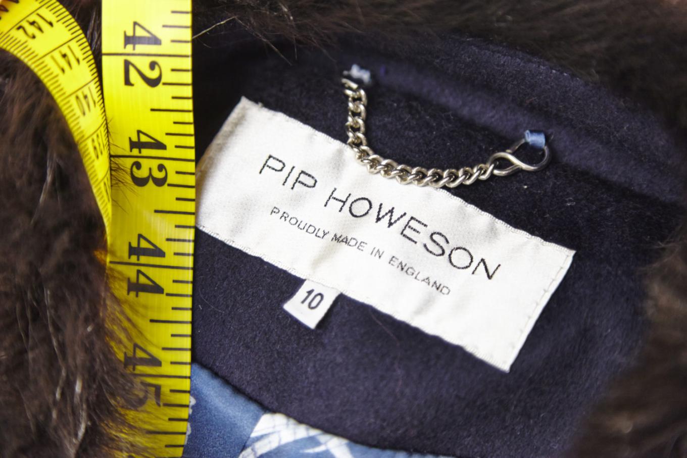 A close up of a Pip Howeson clothes label with a tape measure on top