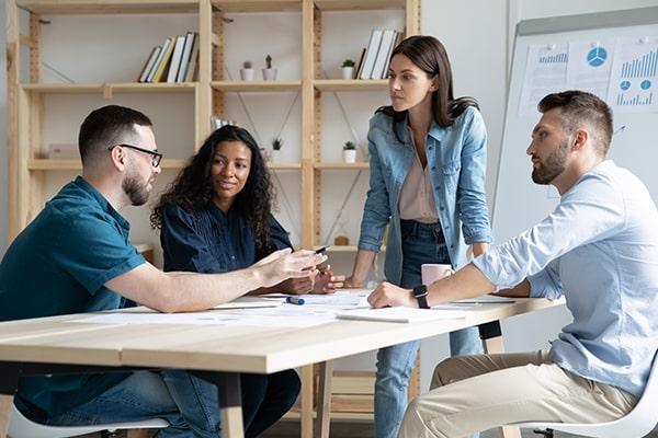 Four young colleagues having a marketing meeting around a desk in a modern office