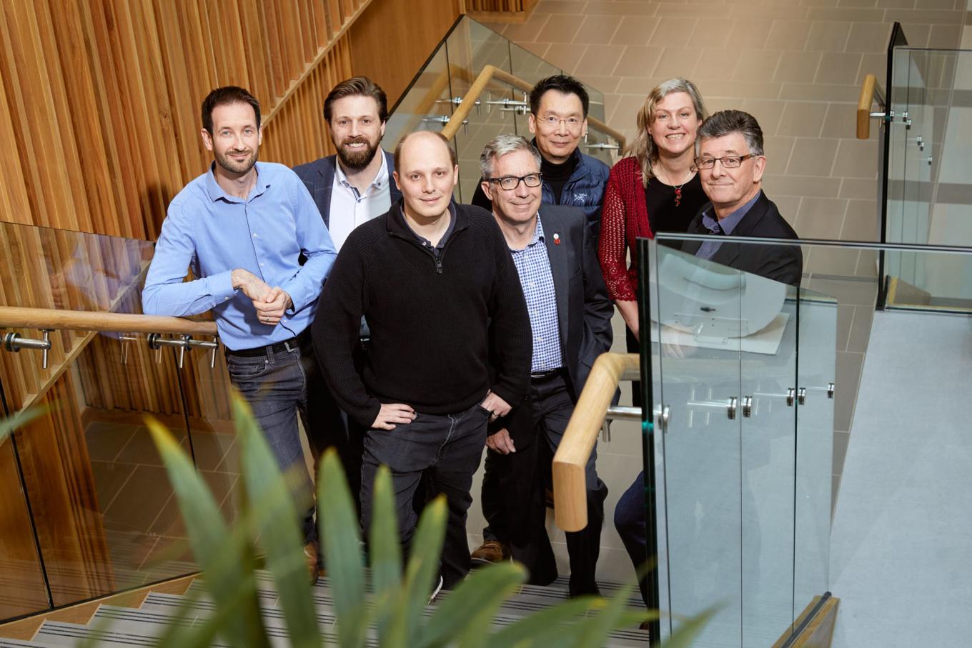 Employees from Slingshot Simulations stood on the stairs in an office