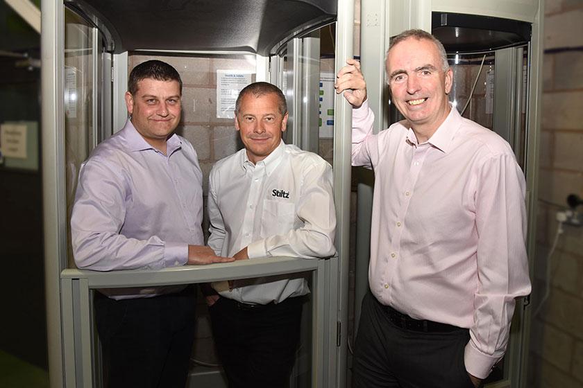 Three men from Stilz standing with their stair lift products