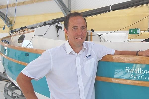 Matt Newland, director of Swallow Yachts, standing beside one of his bespoke boats