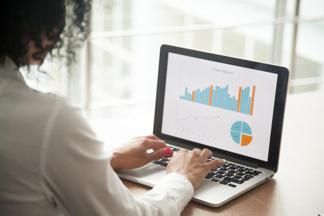 Woman looking at financial graphs on a computer screen