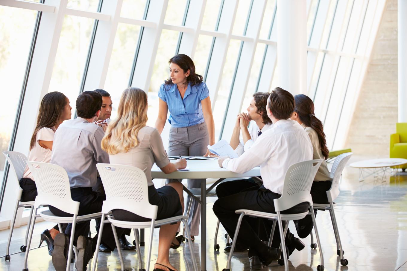 work colleagues sitting and working around a table 