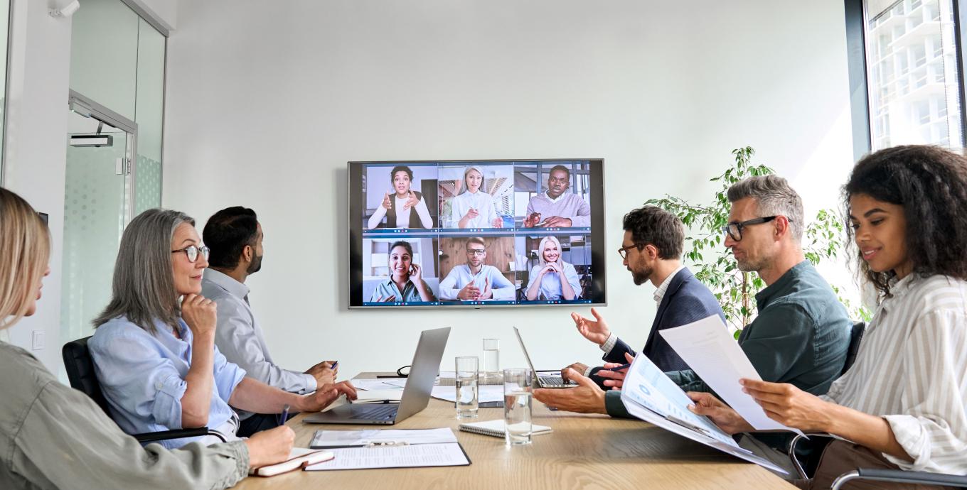 Colleagues sitting around a table on a video conference