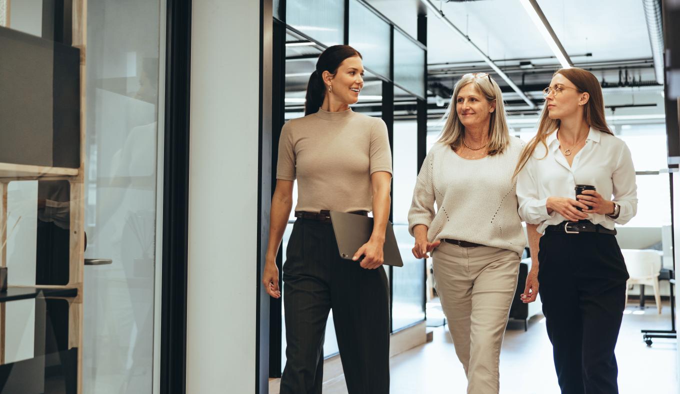 three ladies walking in corporate office