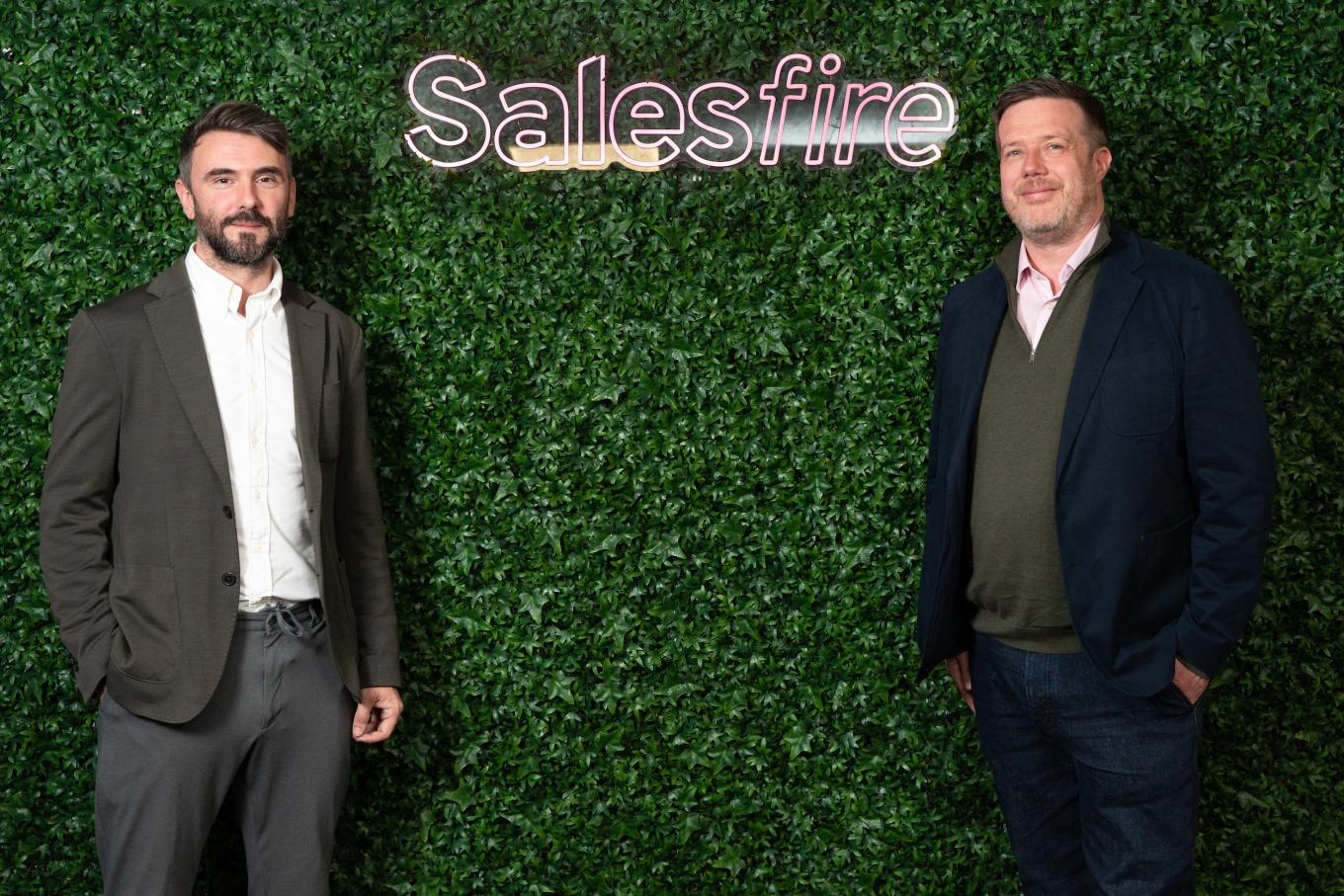 Two men standing next to the Salesfire logo