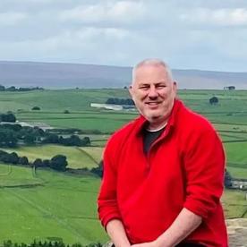 Mike Powell standing in front of a countryside view