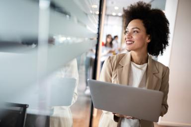 Female employee walking with laptop