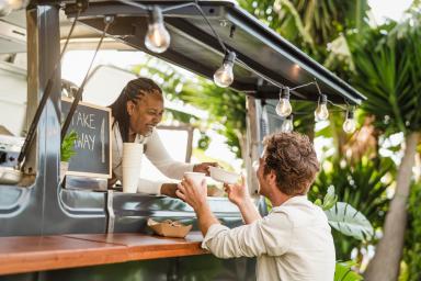 Woman serving food to male customer