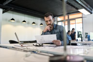 Man in modern office looking at document